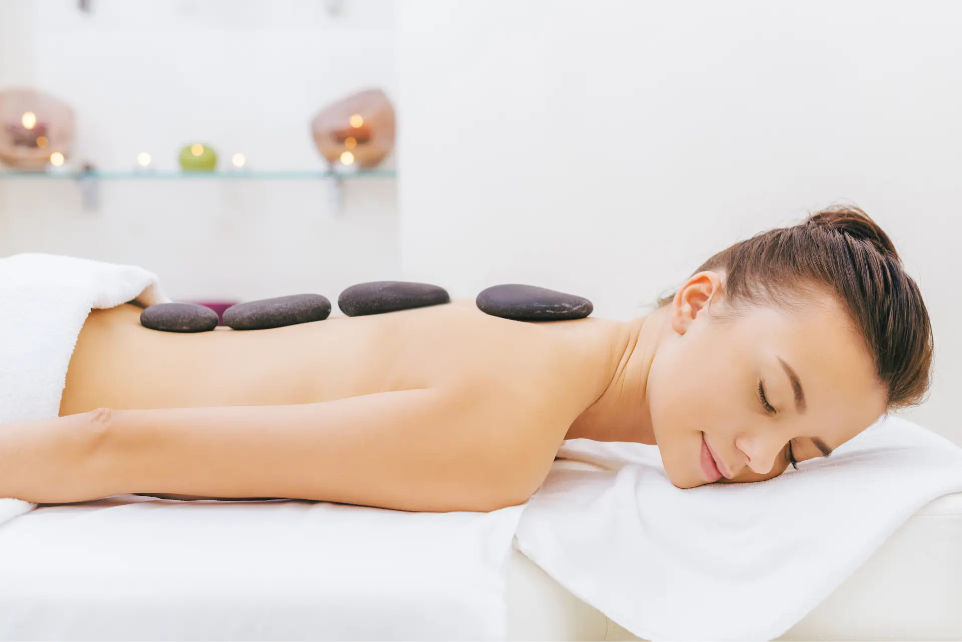 stones on woman's back in spa